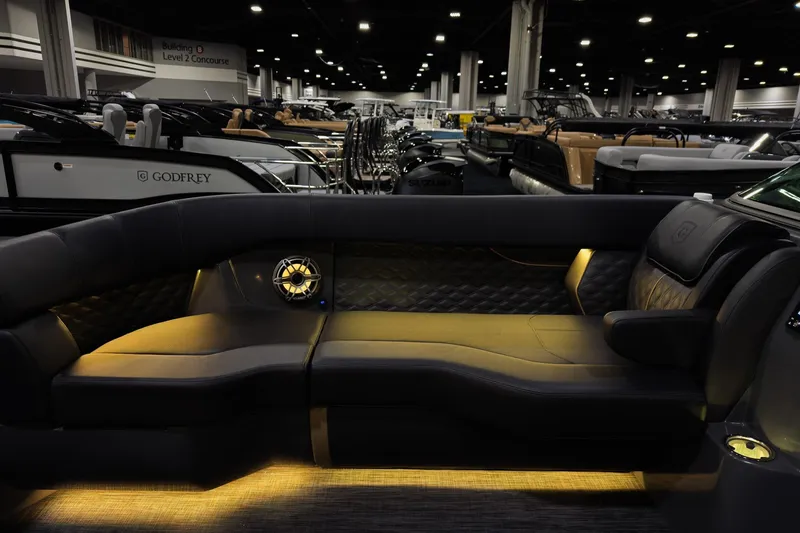 Slide: The Image of Luxurious interior of 2026 Godfrey SanPan 25' Split Bench Windshield boat at a showroom. - 7