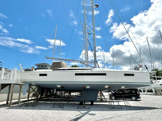 Slide: The Image of 2023 Jeanneau Sun Odyssey 490 sailboat on stands under a bright blue sky. - 0