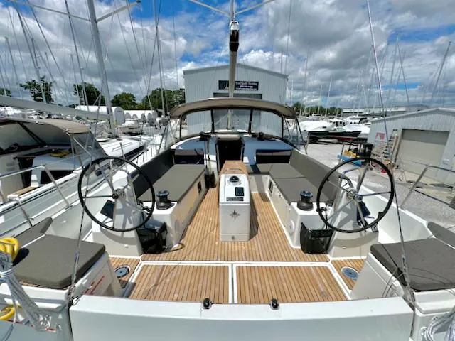 Slide: The Image of 2023 Jeanneau Sun Odyssey 490 sailboat with dual steering wheels and spacious cockpit. - 1