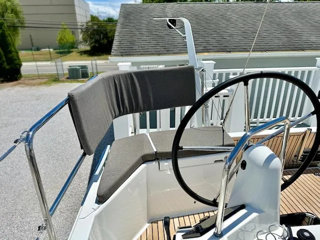 Slide: The Image of 2023 Jeanneau Sun Odyssey 490 helm station with cushioned seating and steering wheel. - 21