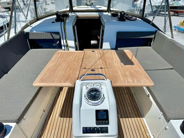 Slide: The Image of 2023 Jeanneau Sun Odyssey 490 cockpit with wooden table and navigation instruments. - 22