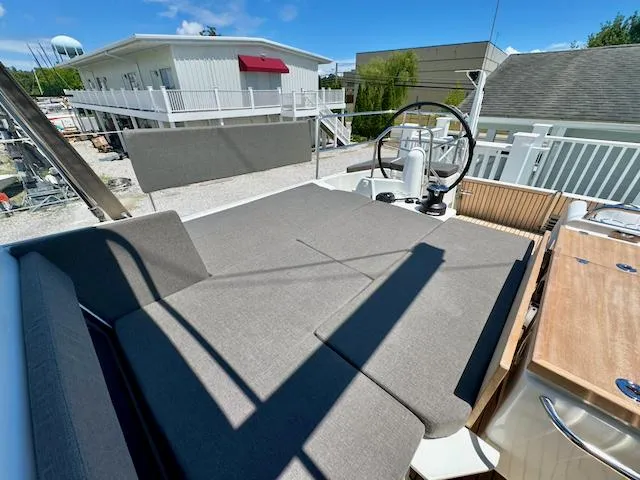 Slide: The Image of 2023 Jeanneau Sun Odyssey 490 yacht deck with steering wheel and seating area. - 24