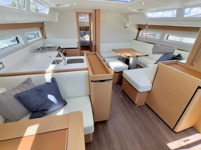 Slide: The Image of Interior of 2023 Jeanneau Sun Odyssey 490 yacht, featuring modern kitchen and dining area. - 27