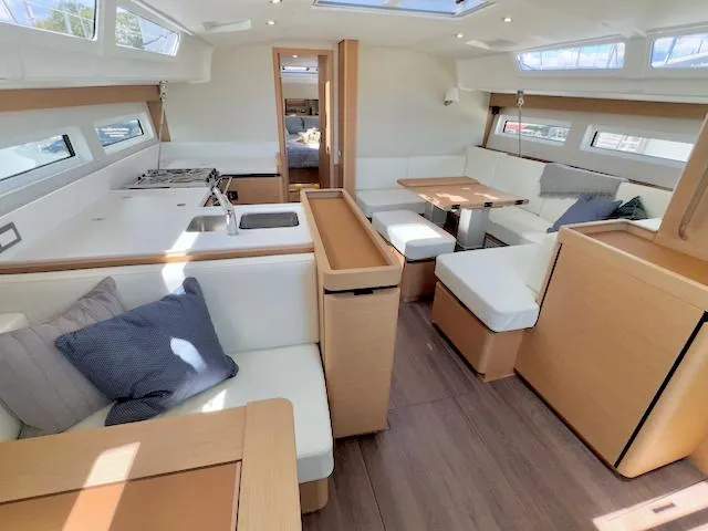 Slide: The Image of Modern interior of 2023 Jeanneau Sun Odyssey 490 yacht with spacious seating and kitchen area. - 28