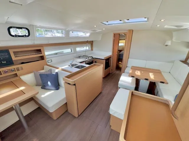 Slide: The Image of Interior of 2023 Jeanneau Sun Odyssey 490 yacht, featuring modern seating and dining area. - 38