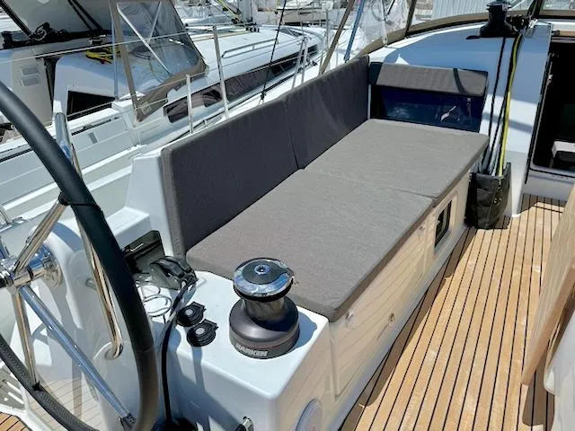 Slide: The Image of 2023 Jeanneau Sun Odyssey 490 yacht deck with seating and steering wheel. - 6