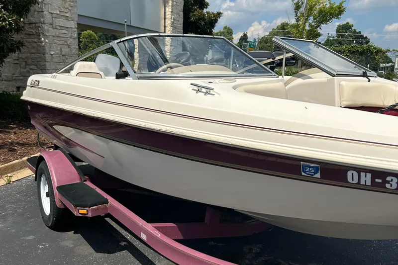 Slide: The Image of 1999 Glastron GS185 SF boat on a trailer, parked outdoors. - 3