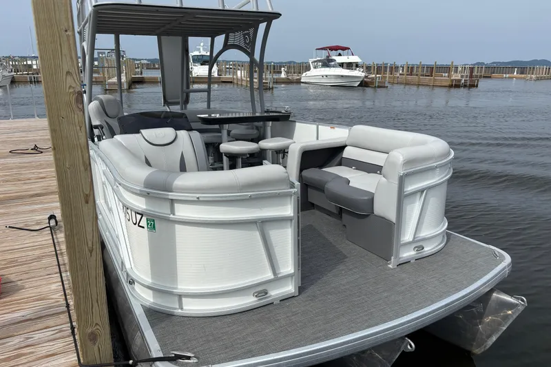 Slide: The Image of 2025 Godfrey MC235SDB pontoon boat docked, featuring spacious seating and modern design. - 1