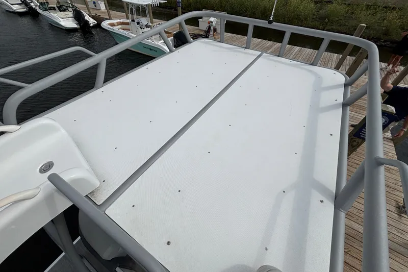 Slide: The Image of Rooftop deck of 2025 Godfrey MC235SDB boat docked at marina. - 9