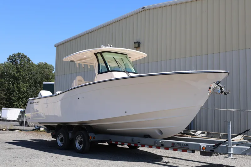 Slide: The Image of 2026 Grady-White Canyon 306 boat on trailer, parked outdoors near a building. - 3
