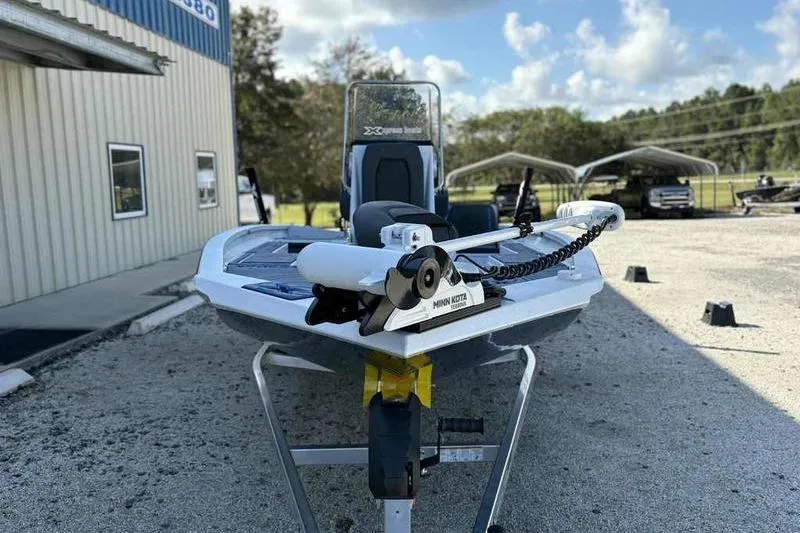 Slide: The Image of 2026 Xpress H20B Bay boat with Minn Kota motor, parked outdoors. - 2