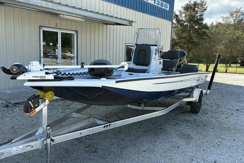 Slide: The Image of 2026 Xpress H20B Bay boat on trailer outside a building. - 5