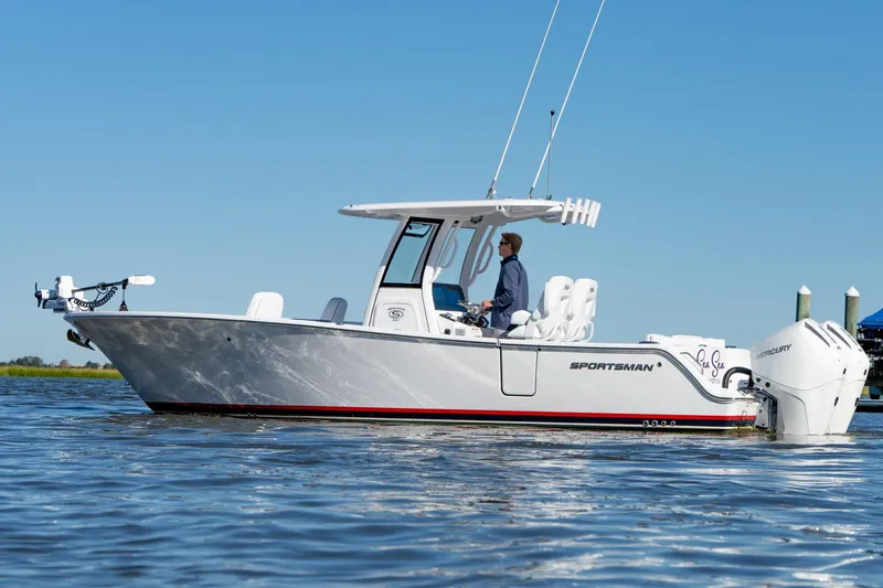 The Image of 2024 Sportsman Heritage 261 Center Console boat on calm water, side view. - 0