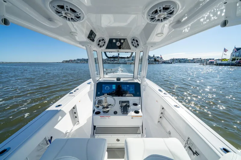 Slide: The Image of 2024 Sportsman Heritage 261 Center Console boat on water, showcasing helm and seating. - 11
