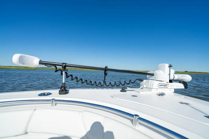Slide: The Image of 2024 Sportsman Heritage 261 Center Console boat with Minn Kota trolling motor on calm water. - 15