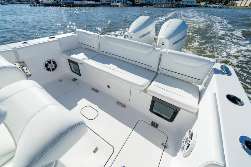 Slide: The Image of 2024 Sportsman Heritage 261 Center Console boat interior with white seating and dual Mercury engines. - 5