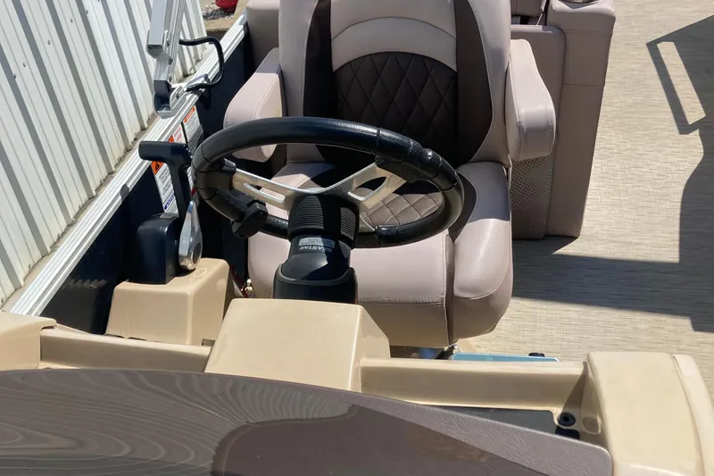Slide: The Image of 2018 Bennington 23 SX boat interior with cushioned seating and cup holder by the water. - 15