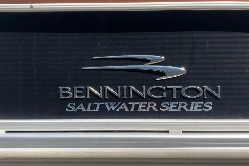 Slide: The Image of 2018 Bennington 23 SX pontoon boat docked in a marina under a clear sky. - 2