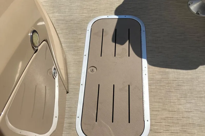 Slide: The Image of 2018 Bennington 23 SX boat deck with beige flooring and storage hatch. - 25