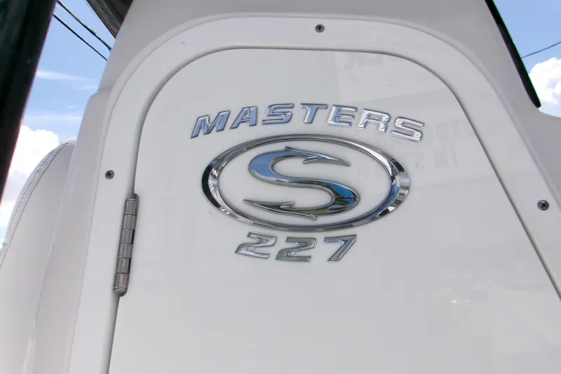 Slide: The Image of 2024 Sportsman Masters 227 Bay Boat logo on white surface. - 17
