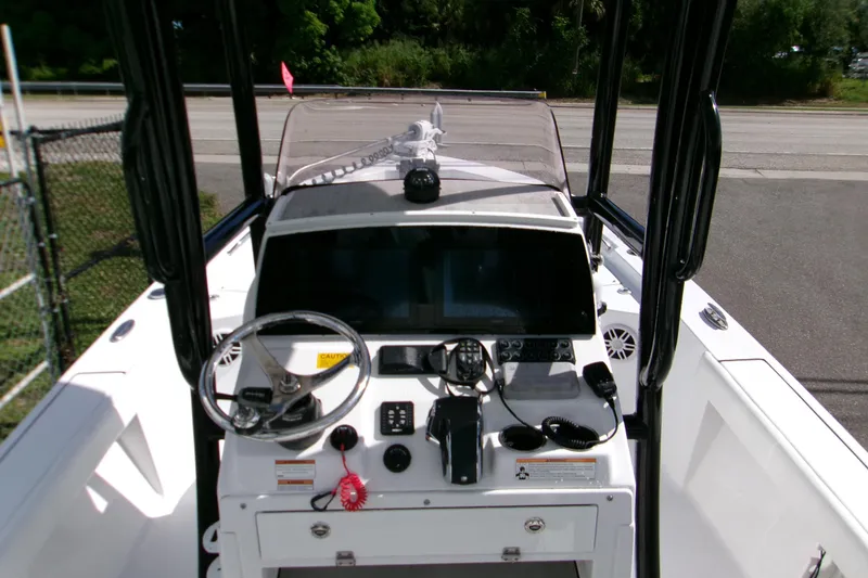 Slide: The Image of 2024 Sportsman Masters 227 Bay Boat dashboard with steering wheel and navigation equipment. - 2