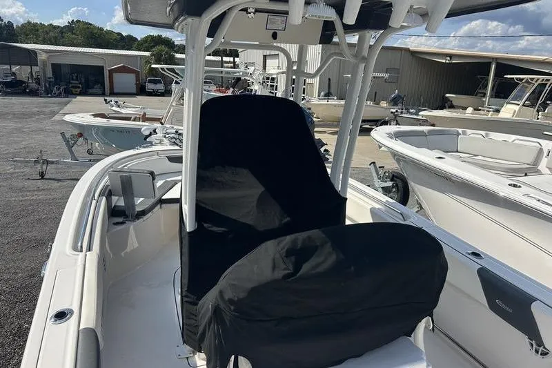 Slide: The Image of 2022 Robalo R242 Center Console boat with covered seats and console in a parking area. - 33