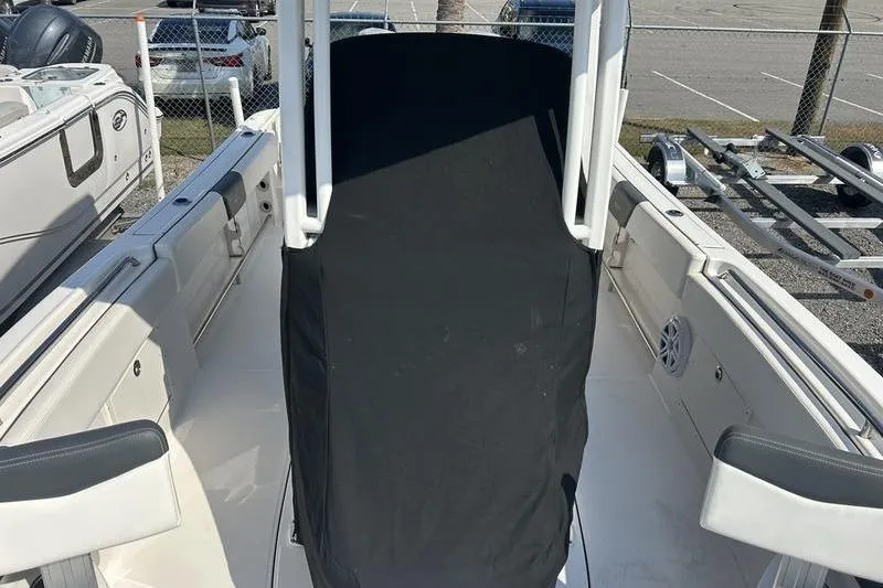 Slide: The Image of 2022 Robalo R242 Center Console boat with covered engines in a parking lot. - 34