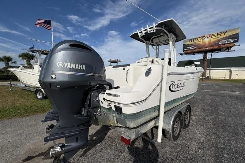 Slide: The Image of 2022 Robalo R242 Center Console boat on trailer under blue sky. - 4