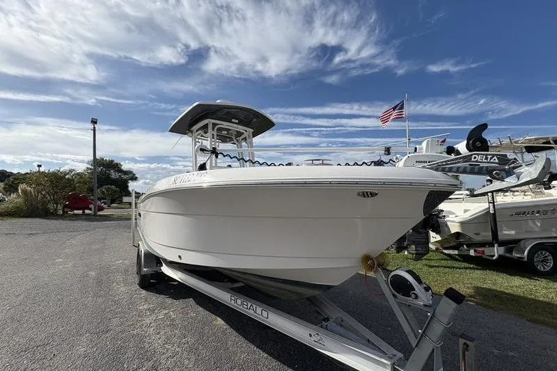 Slide: The Image of 2022 Robalo R242 Center Console boat on trailer under a partly cloudy sky. - 6