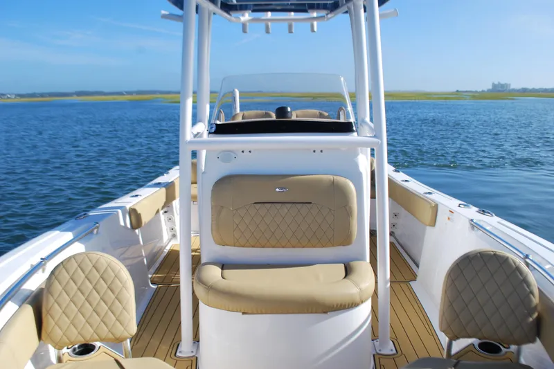 Slide: The Image of 2023 Sportsman Heritage 211 Center Console boat on calm water, featuring tan seating and sleek design. - 10