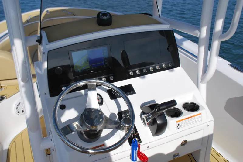 Slide: The Image of 2023 Sportsman Heritage 211 Center Console boat dashboard with steering wheel and controls. - 11