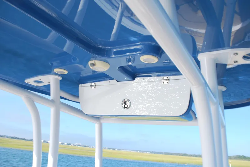 Slide: The Image of 2023 Sportsman Heritage 211 Center Console T-top with storage compartment, blue and white design. - 16