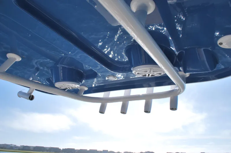 Slide: The Image of 2023 Sportsman Heritage 211 Center Console boat, blue T-top with rod holders and speakers. - 17