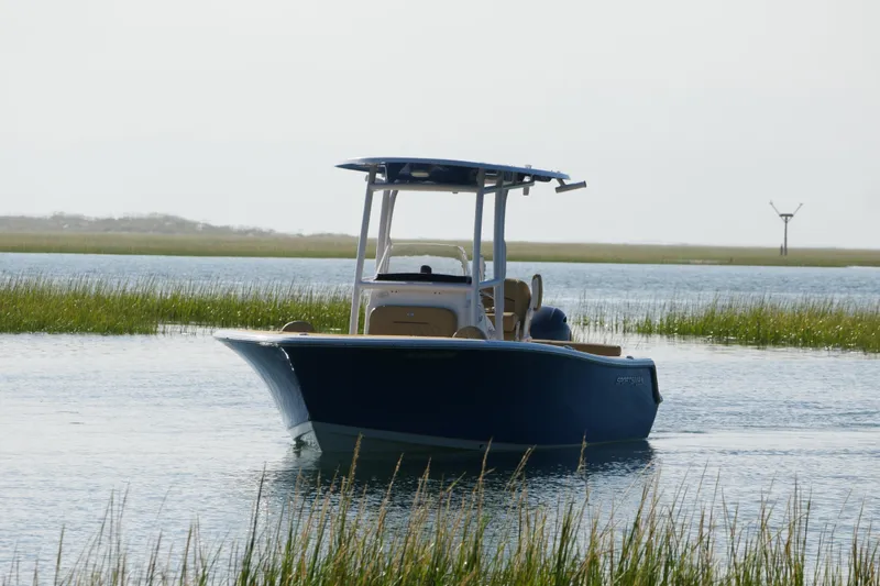 Slide: The Image of 2023 Sportsman Heritage 211 Center Console boat on calm water, surrounded by marshland. - 3