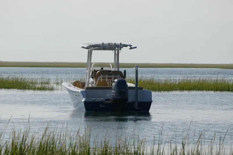 Slide: The Image of 2023 Sportsman Heritage 211 Center Console boat on calm water, surrounded by marshland. - 4