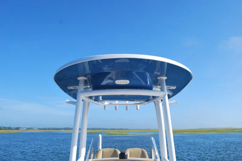 Slide: The Image of 2023 Sportsman Heritage 211 Center Console boat on calm water under clear blue sky. - 8
