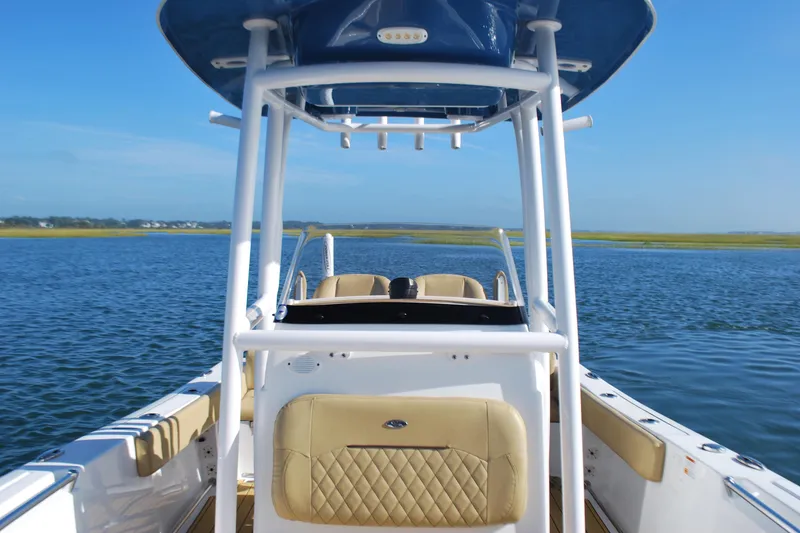 Slide: The Image of 2023 Sportsman Heritage 211 Center Console boat on calm water, featuring sleek design and spacious seating. - 9