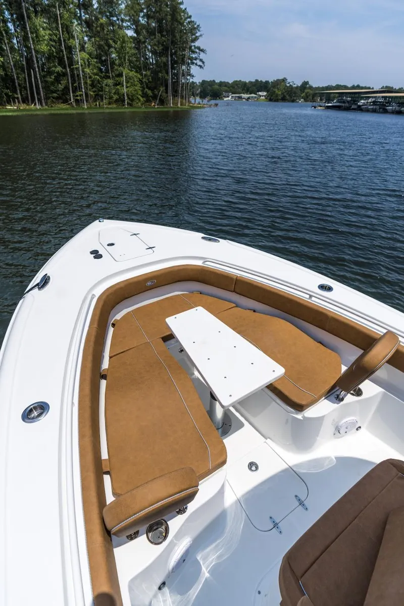Slide: The Image of 2025 Sea Hunt Ultra 305 SE boat with tan seating on a serene lake. - 19