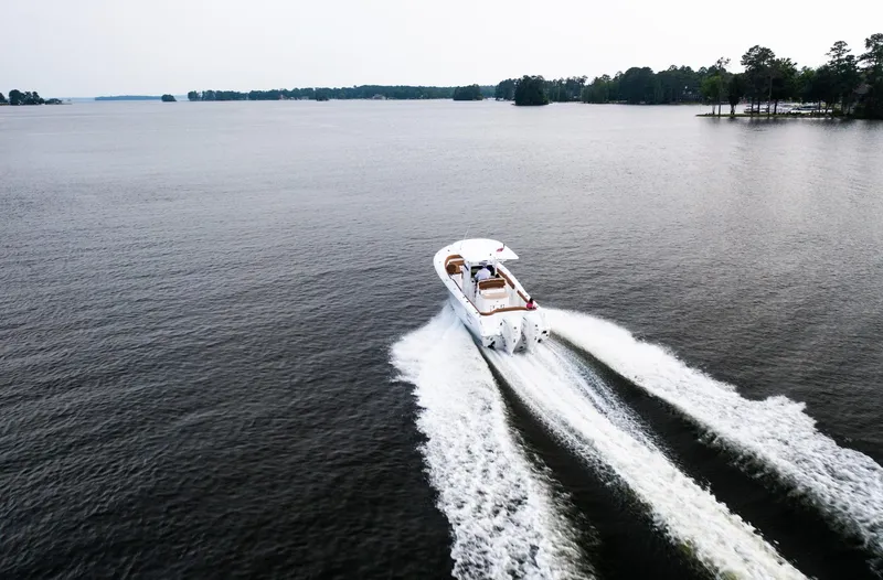 Slide: The Image of 2025 Sea Hunt Ultra 305 SE cruising on a serene lake. - 7