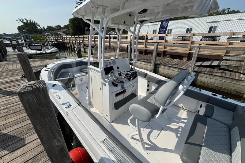 Slide: The Image of 2024 NauticStar 222OSL boat docked, featuring sleek design and modern seating arrangement. - 4