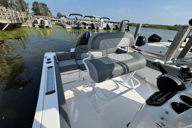 Slide: The Image of 2024 NauticStar 222OSL boat interior with gray seating at a dock. - 6