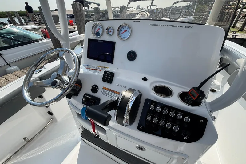 Slide: The Image of 2024 NauticStar 222OSL boat dashboard with steering wheel and control panel. - 8