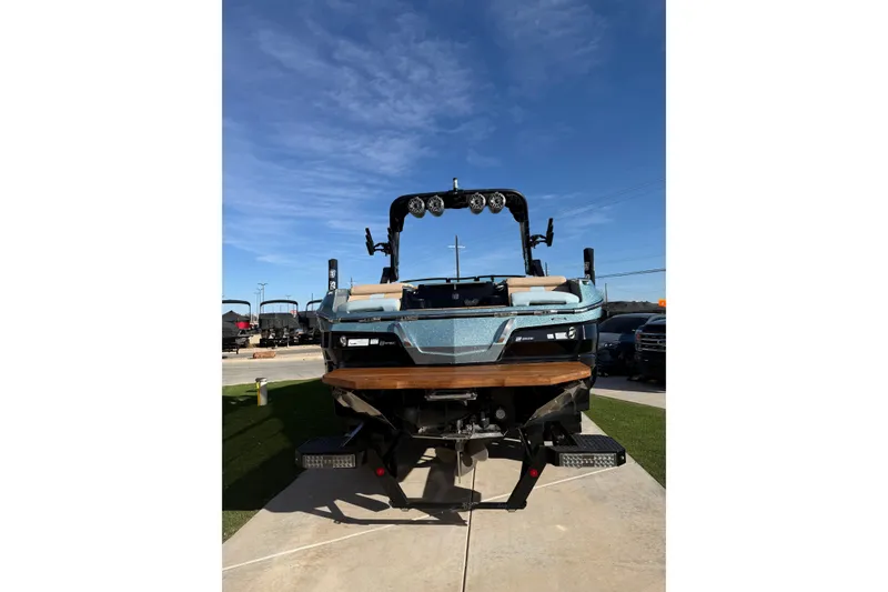 Slide: The Image of 2022 MasterCraft X24 boat displayed outdoors under clear blue sky. - 19