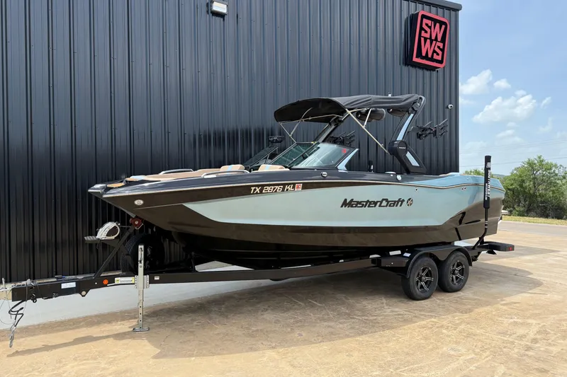 Slide: The Image of 2022 MasterCraft X24 boat on trailer, parked outside SWWS building. - 2