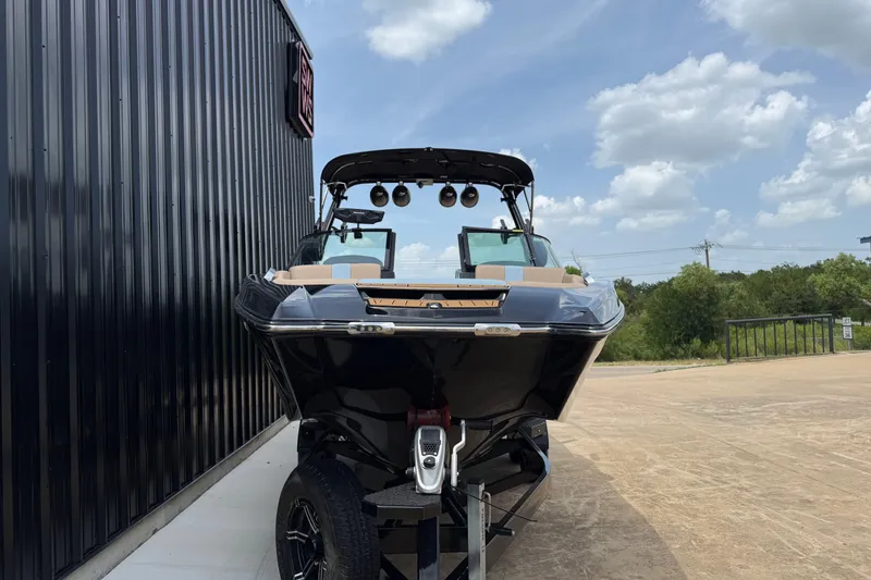 Slide: The Image of 2022 MasterCraft X24 boat on trailer, parked outdoors under a partly cloudy sky. - 3