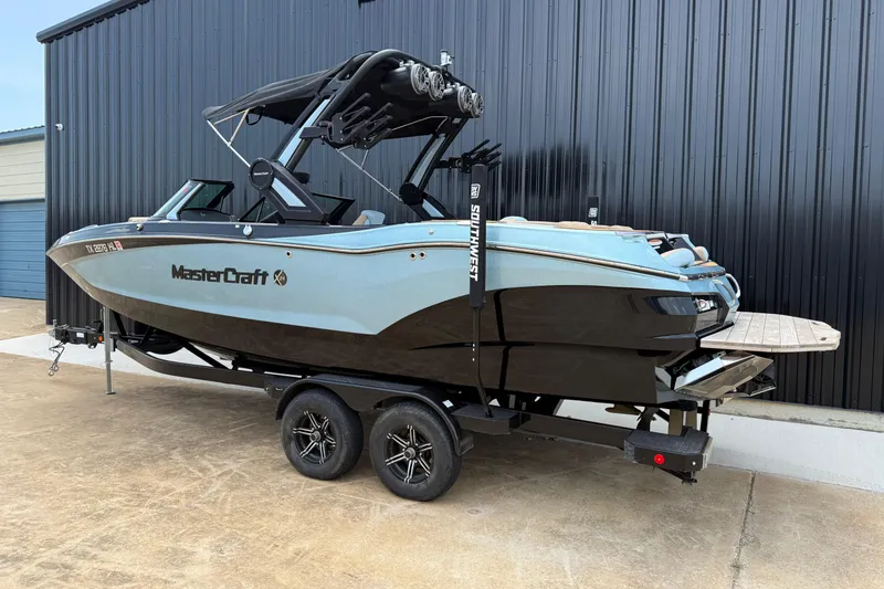Slide: The Image of 2022 MasterCraft X24 boat on trailer, parked by a black building. - 4