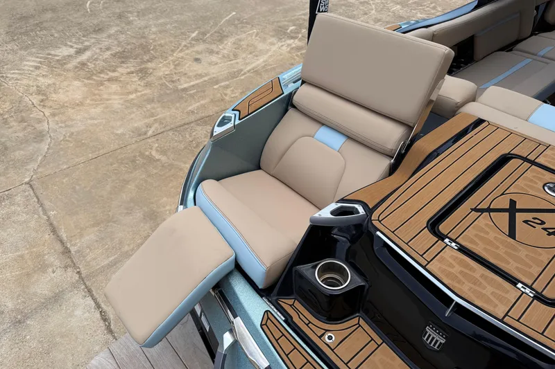 Slide: The Image of 2022 MasterCraft X24 boat interior with tan seating and wood accents. - 6