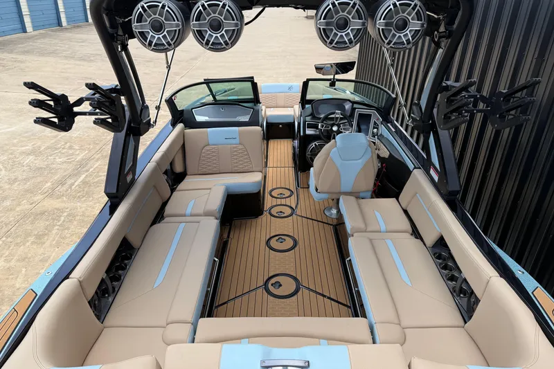 Slide: The Image of 2022 MasterCraft X24 boat interior with beige seating and advanced audio system. - 7