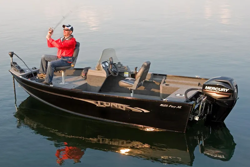 Slide: The Image of 2018 Lund 1625 Fury XL SS boat in parking lot, red exterior, outboard motor visible. - 1
