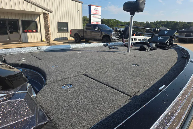 Slide: The Image of 2020 Ranger Z521L boat deck with fishing seat and equipment, parked outside a marine shop. - 6